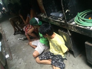 Several of the 34 drug suspects nabbed by the Quezon City Police District and the Philippine Drug Enforcement Agency, sit on the ground, waiting to be transferred to the city jail on Sept. 1, 2016.  The cops and the PDEA seized sachets of shabu and drug paraphernalia during raids of three "drug dens" in Barangay Pasong Tamo. (Photo by Maricar Brizuela / INQUIRER)