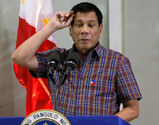 FILE - In this Aug. 31, 2016, file photo, Philippine President Rodrigo Duterte gestures as he addresses Overseas Filipino Workers who were repatriated back to the country at the Ninoy Aquino International Airport in Pasay city, south of Manila, Philippines. Duterte, who disparaged the pope and others who controvert his worldview, warns U.S. President Barack Obama on Monday, Sept. 5, 2016, not to question him about extrajudicial killings. (AP Photo/Bullit Marquez, File)