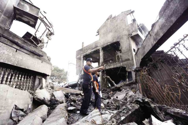 A policeman inspects the ruins of a firecracker factory after the Oct. 12 blast in Bocaue, Bulacan province. —NIÑO JESUS ORBETA