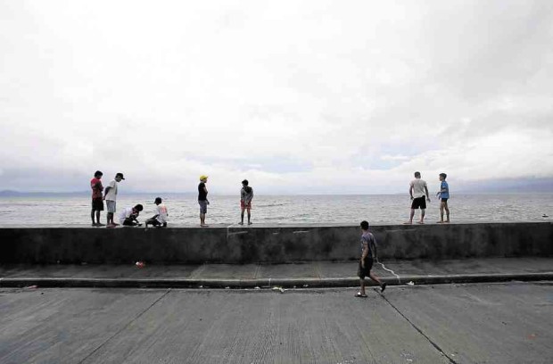 As thousands try to cross stormy seas from the Matnog port in Sorsogon to reach homes in Samar to celebrate Christmas with loved ones, residents of Legazpi City watch the waters off the city shore turn turbulent as Typhoon “Nina” drew closer. —MARC ALVIC ESPLANA