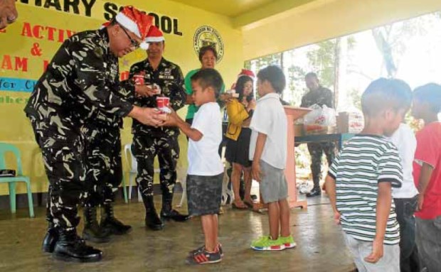 SOLDIER SANTAS Christmas away from homemeans outreach activities in the community like this feeding program in Malaybalay, Bukidnon province. —PHOTO FROMAFP FOURTH INFANTRY DIAMOND DIVISION