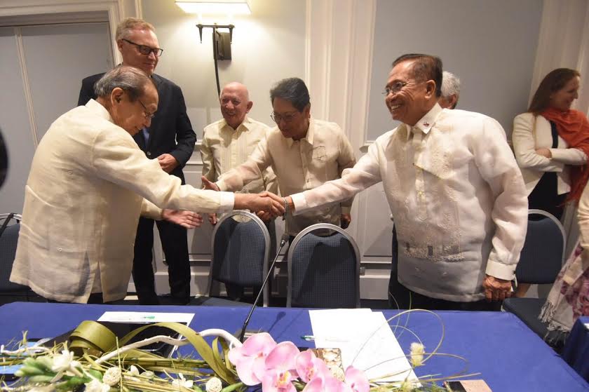 Presidential Peace Adviser Jesus Dureza (right), Labor Secretary Silvestre Bello III (second from right) , shake hands with Communist Party of the Philippines founder Jose Maria Sison (left) and Fidel Agcaoili (center) of the National Democratic Front of the Philippines after they sign an agreement in Rome, Italy, that would be the basis for future talks on socio-economic reforms. (Photo release from the Office of the Presidential Adviser on the Peace Process)