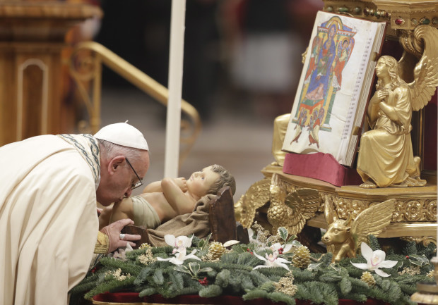 Pope Francis kisses a statue of the Infant Jesus as he celebrates a new year's eve vespers Mass in St. Peter's Basilica at the Vatican, Saturday, Dec. 31, 2016. (AP Photo/Andrew Medichini)