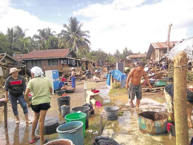 Residents of the village of Sagunto in La Paz town, Agusan del Sur, clean up after flooding swept homes and structures after unrelenting rains. —JEFFREY SALINAS/CONTRIBUTOR