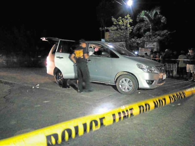 Policemen inspect the car of lawyer Mia Manuelita Mascariñas-Green, who died in an ambush staged by four men in Tagbilaran City on Wednesday. —LEO UDTOHAN