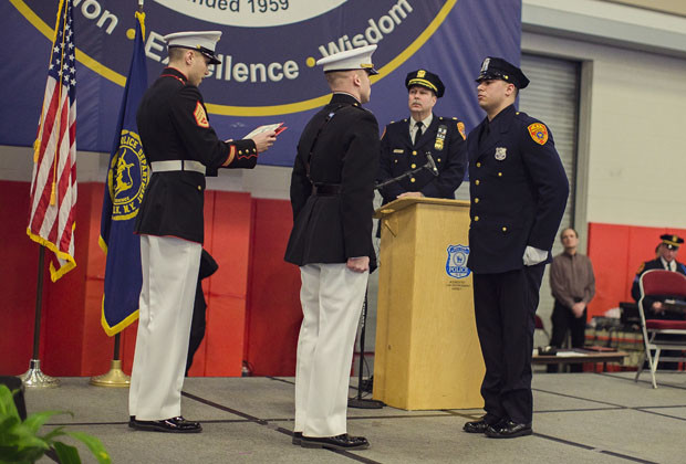 Matias Ferreira, center, receives his diploma during his graduation from the Suffolk County Police Department Academy at the Health, Sports and Education Center in Suffolk, Long Island, New York, Friday, March 24, 2017. Ferreira, a former U.S. Marine Corps lance corporal who lost his legs below the knee when he stepped on a hidden explosive in Afghanistan in 2011, is joining a suburban New York police department. The 28-year-old graduated Friday from the Suffolk County Police Academy on Long Island following 29 weeks of training. (AP Photo/Andres Kudacki)