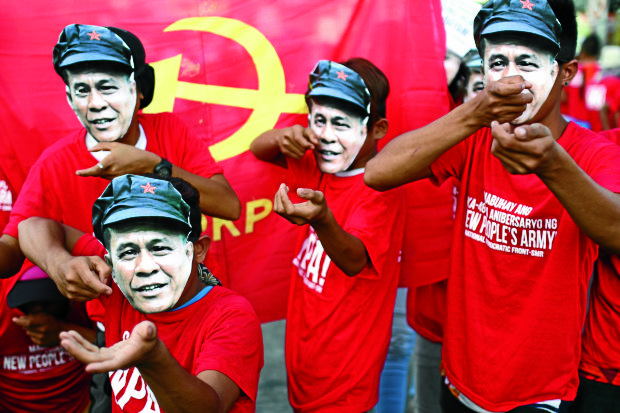 RED RALLY IN DAVAO Communist supporters wearingmasks of the lateNew People’s Army (NPA) leader Leoncio Pitao, alias Kumander Parago, hold a lightning rally at a busy intersection in Davao City to mark the 48th founding anniversary of theNPA on Tuesday. —KARLOS MANLUPIG