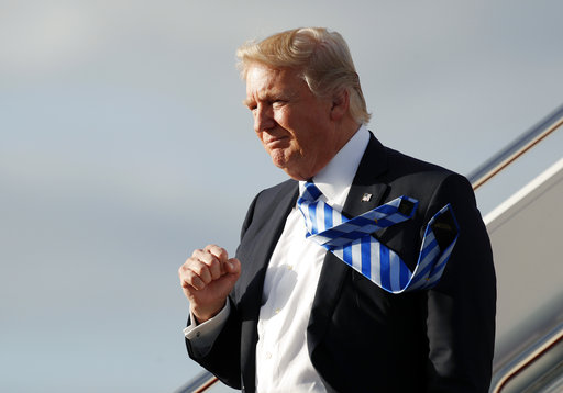 President Donald Trump pumps his fist as he walks down the steps off Air Force One as he arrives at the Palm Beach International Airport, Thursday, April 13, 2017, in West Palm Beach, Fla. (AP Photo/Alex Brandon)