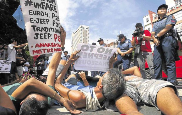DIE-IN Jeepney drivers and their supporters stage a die-in along a busy Manila road to signal the start of a two-day nationwide strike to protest the government’s phaseout of old jeepneys. —BULLIT MARQUEZ / AP