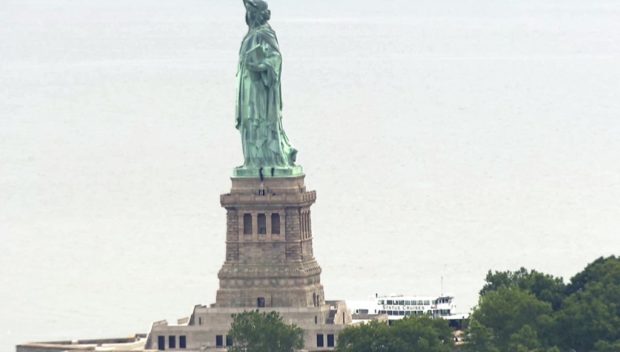 Liberty Island evacuated after statue base climber, banner