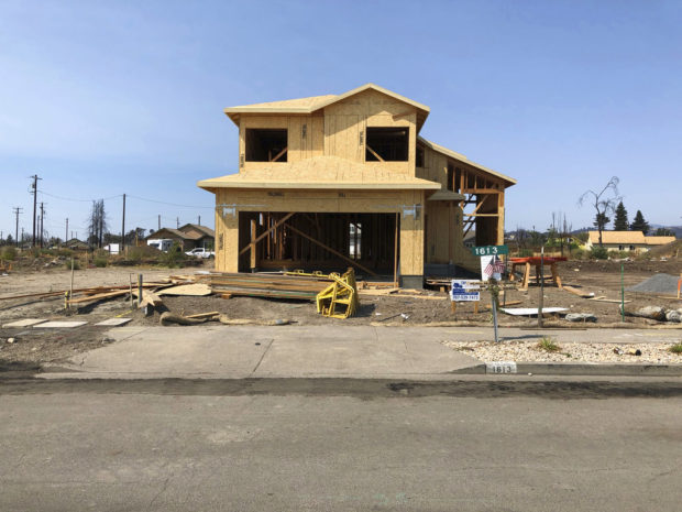 In this Friday, August 10, 2018, photo the partially rebuilt home of Debbie and Rick Serdin in the Coffey Park neighborhood in Santa Rosa, Calif. The Trump administration's tariffs have raised the cost of imported lumber, drywall, nails and other key construction materials, squeezing homeowners who seek to rebuild quickly after losing their houses to natural disasters, such as the wildfires that destroyed Coffey Park. (AP Photo/Jonathan J. Cooper)