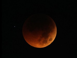 The moon exhibits a deep orange glow as the Earth casts its shadow in a total lunar eclipse as seen in Manila before dawn Thursday. Asian and African night owls were treated to a lunar eclipse, and ash in the atmosphere from a Chilean volcano turned it blood red for some viewers. AP