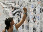 A woman writes a message on the wall of remembrance memorial near the World Trade Center on September 10, 2011 in New York. US President Barack Obama on Saturday called for a "heightened state of vigilance and preparedness" as the United States marks the 10th anniversary of 9/11 under a terror threat, the White House said.   AFP PHOTO/DON EMMERT