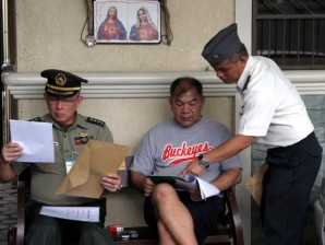 READING THE CHARGE SHEET. Lieutenant Colonel Edwin Machica of the Office of The Judge Advocate General (standing) and Colonel Herbert Yambing (seated left) read to Major General Garcia the full contents of his sentence as confirmed by President Benigno Aquino III. AFP-PIO
