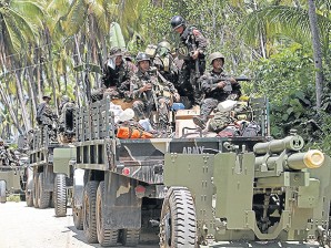 BIG GUNS. Army soldiers  are on high alert aboard military trucks towing howitzers for repositioning in Barangay Sta. Maria, Alicia, Zamboanga Sibugay, on Friday. RAFFY LERMA