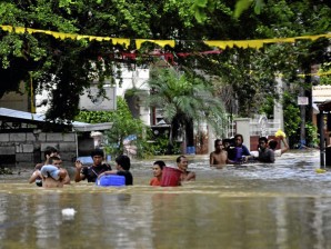 Residents wade through the floodwaters as they evacuate to safer grounds following massive flooding in Calumpit, Bulacan and worsened by typhoon Quiel that brings heavy rains and flash flood in the area.ARNOLD ALMACEN/INQUIRER