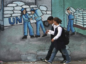 FOR THE CHILDREN. Palestinian school girls walk past a graffiti on a wall depicting UN humanitarian aid supplies, in Gaza City, Monday, Oct. 31, 2011. Palestine became a full member of the U.N. cultural and educational agency Monday, in a highly divisive move that the United States and other opponents say could harm renewed Mideast peace efforts. AP Photo/Adel Hana