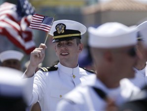 A sailor waves a flag during the gay pride parade Saturday, July 21, 2012, in San Diego. For the first time ever, U.S. service members marched in a gay pride event decked out in uniform Saturday, after a recent memorandum from the Defense Department to all military branches made an allowance for the San Diego parade - even though its policy generally bars troops from marching in uniform in parades. (AP Photo/Gregory Bull)