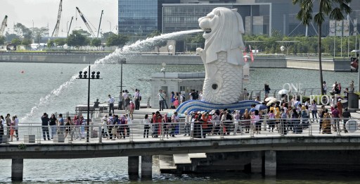 Visitors gather along the pier in front of the iconic sculpture of the Merlion in Singapore on January 29, 2013. Asia's tourism industry must prepare for  major changes in the next 20 years, including a projected boom in travel by senior citizens and female business executives, a study said January 29 . AFP PHOTO/ROSLAN RAHMAN