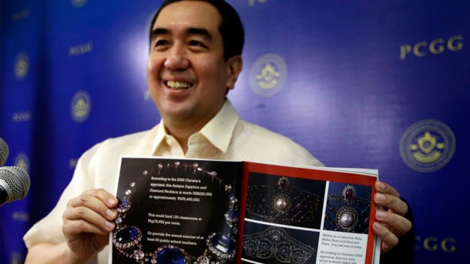Andres Bautista, chairman of the Presidential Commission on Good Government, which is tasked with recovering the alleged ill-gotten wealth of the late dictator Ferdinand Marcos and his family, shows a catalog of a seized jewelry collection belonging to the Marcoses at a news conference Tuesday, Jan. 14, 2014. The antigraft court has ruled the collection is ill-gotten. AP PHOTO/BULLIT MARQUEZ