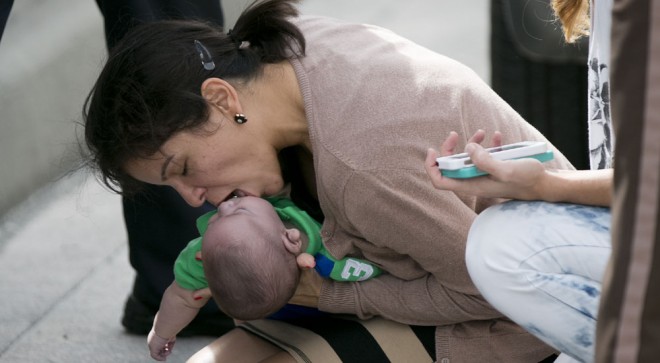Pamela Rauseo, 37, performs CPR on her nephew, five-month-old Sebastian de la Cruz, after pulling her SUV over on the side of the road along the west bound lane on Florida state road 836 just east of 57th Avenue around 2:30 pm on Thursday, Feb. 20, 2014. At right is Lucila Godoy who stopped her car to assist in the rescue. The baby was rushed to Jackson Memorial Hospital, where he is reportedly doing ok. AP
