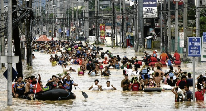 Rescuers ferry stranded residents from their houses due to floods caused by Typhoon Ondoy along Ortigas in Cainta Rizal. INQUIRER FILE PHOTO