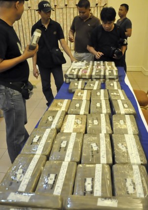 Police arrange bricks of high-grade cocaine prior to being presented to the media at the Davao City Hall in Davao city in southern Philippines Monday, March 24, 2014. Drug Enforcement authorities said the illegal drug, which was discovered concealed in a containerized cargo Saturday, was valued at 300 million pesos ($6.6 million). AP