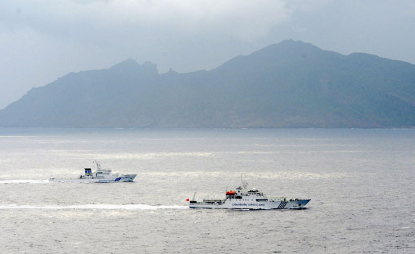 In this April 23, 2013 file photo, a Japan Coast Guard vessel, left, sails along with a Chinese surveillance ship near the disputed islands called Senkaku in Japan and Diaoyu in China in the East China Sea. Striving to allay Japan’s worries over its territorial dispute with China and missile launches by North Korea, during a recent Asian tour U.S. Defense Secretary Chuck Hagel pledged two more ballistic missile defense destroyers for Japan by 2017. In a further show of solidarity, Hagel rebuked Beijing for escalating its territorial dispute with Tokyo over Japanese-controlled islands in the East China Sea, which Japan calls the Senkakus and China calls the Diaoyu islands. AP