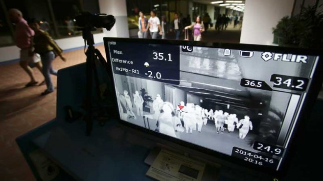 Passengers walk past a thermal scanner at the medical quarantine area at the arrival section of Manila’s International Airport in Paranaque. AP FILE PHOTO