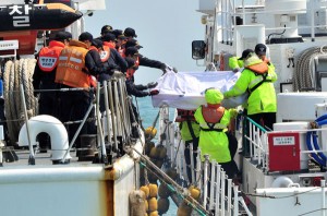 South Korea Coast Guard members transfer the bodies of passengers from the sunken South Korean ferry 'Sewol', to a ship at sea off Jindo on April 20, 2014. Divers began retrieving bodies on April 20 from inside the submerged South Korean ferry that capsized four days ago with hundreds of children on board, as families angered by the pace of the rescue efforts scuffled with police. AFP P 