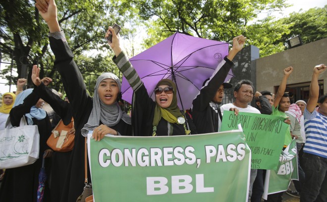 Filipino Muslims shout slogans during a rally outside the House of Representatives in Quezon City on Monday, May 5, 2014, to call for support to a recently signed peace agreement between the government and the largest Muslim rebel group in the country. BBL on the sign means Bagsamoro Basic Law.  AP 