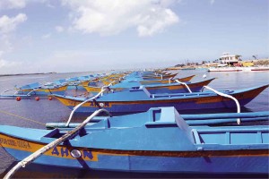 BOATS painted blue are docked on the shores of Bantayan Island, awaiting distribution to fishermen who lost their only source of livelihood when Supertyphoon “Yolanda” destroyed their boats.  LITO TECSON/CEBU DAILY NEWS