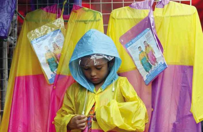 GEARING UP A child tries on a raincoat at the Divisoria market district in Manila on Saturday. NIÑO JESUS ORBETA 