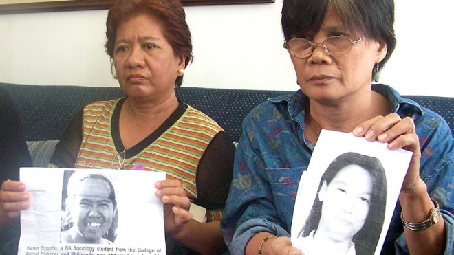 Concepcion Empeño (center) and Erlinda Cadapan, mothers of missing UP students Karen Empeño and Sherlyn Cadapan hold pictures of their daughters during a meeting with Sen. Mar Roxas. RODEL ROTONI/INQUIRER FILE PHOTO