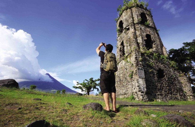 MEGA MAGMA MOVES  After a week of quiet, Mayon Volcano could erupt in weeks, says the Philippine Institute of Volcanology and Seismology. A backpacker shoots the postcard-pretty scenery from a safe distance—the ruins of Casagwa Church in Daraga town, Albay province. MARK ALVIC ESPLANA/INQUIRER SOUTHERN LUZON 