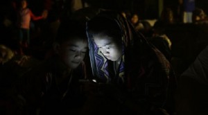 Children play with their cellphone, at an evacuation center after heavy monsoon rains spawned by tropical storm Fung-Wong (local name Mario) flooded Marikina city, east of Manila, Philippines and most parts of the metropolis, Friday, Sept. 19, 2014. AP