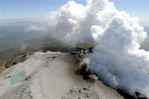 An aerial view shows volcanic smoke and fume raising from craters of Mount Ontake, central Japan, Tuesday, Sept. 30, 2014. AP