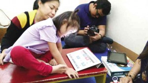 A GIRL with special needs picks a toy from pictures on the iPad and tells clinic director Marie Chris Palafox-Pascua.