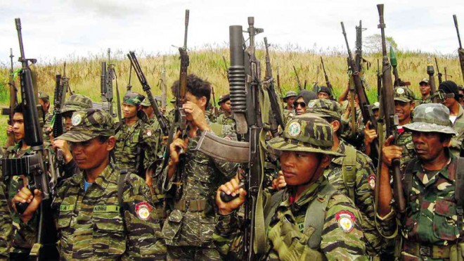 JUNGLE DRILL  Fighters of the Moro Islamic Liberation Front raise their weapons during a drill in the jungles of Kinebaka in Datu Odin Sinsuat town, Maguindanao province, in this file photo. The MILF and government negotiators have been meeting in Kuala Lumpur to discuss the difficult process of disarmament under a peace agreement to end a decades-long insurgency in Mindanao.  JEOFFREY MAITEM/INQUIRER MINDANAO