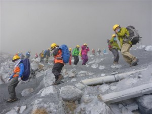 In this photo taken by an anonymous climber and was offered to Kyodo News, climbers descend Mt. Ontake to flee as the volcanic mountain erupts in central Japan, Saturday, Sept. 27, 2014. With a sound likened to thunder, the 3,067-meter (10,062-foot) mountain spewed large white plumes high into the sky, sending people fleeing, covering surrounding areas in ash, with more than 250 people stuck on the slopes for hours, many taking refuge in mountain lodges that dot the way up. AP Photo/Kyodo News