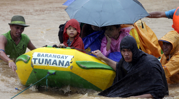 Rescuers use a rubber dinghy to rescue trapped residents after heavy monsoon rains spawned by tropical storm Fung-Wong flooded Marikina city, east of Manila, Philippines and most parts of the metropolis Friday, Sept. 19, 2014. Heavy rains due to a storm and the seasonal monsoon caused widespread flooding Friday in the Philippine capital and nearby provinces, shutting down schools and government offices. Local authorities reported thousands were evacuated early Friday from severely inundated communities, some under rapid-flowing flood waters more than neck high. AP