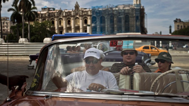 Tourists sit in a classic American car in Old Havana, Cuba, Friday, Sept. 26, 2014. Tourism is one of Cuba’s top four generators of income, along with nickel mining, medical services and remittances from relatives living abroad. (AP Photo/Franklin Reyes)