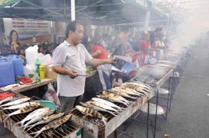 STREET FOOD Residents and tourists (left) seek the familiar taste of Dagupan “bangus” grilled to perfection.