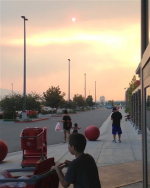 Smoke and haze from a wildfire more than 50 miles away darkens the sky over a shopping center parking lot in Sparks, Nev., late Sunday afternoon, Sept. 14, 2014. The wildfire, about 60 miles east of Sacramento, forced the evacuation of 133 homes. AP