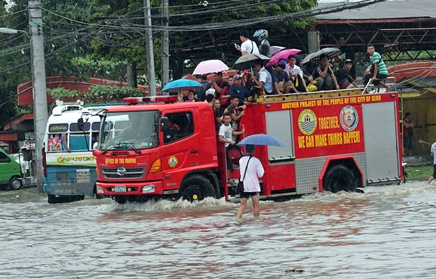 A Cebu City government owned fire truck rescued stranded passengers at the Logarta street corner F. Cabahug street by transporting them to a nearby area with less water. (CDN PHOTO/JUNJIE MENDOZA) 