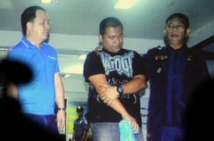 Inspector Joseph De Vera, one of the suspects in the Edsa abduction-robbery, is presented to media by police officials during a press conference at the Philippine National Police headquarters in Camp Crame. LYN RILLON/INQUIRER FILE PHOTO 