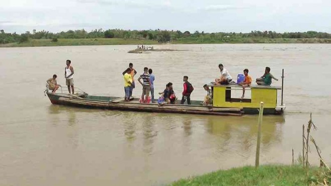 VILLAGERS rode a boat on the Santo Tomas-Cabagan River as the overflow bridge on Sept. 15 was submerged in floodwater due to Typhoon “Luis.” VILLAMOR VISAYA JR./INQUIRER NORTHERN LUZON