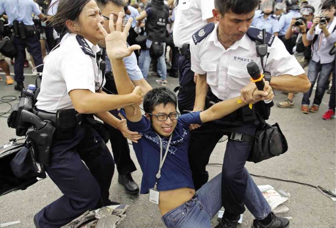 SCUFFLES AT SHOPPING DISTRICT A prodemocracy protester is hauled away by police as scuffles broke out  in a shopping district in Hong Kong on Friday. Supporters of Chinese rule stormed tents and  ripped down banners belonging to prodemocracy protesters. Protesters earlier welcomed an overnight offer of talks by the territory’s leader to defuse the crisis.  AP