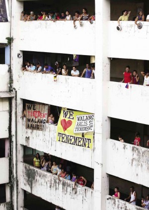 ‘CONDEMNED CONDO’ Residents of the Fort Bonifacio Tenement Building, a 51-year-old mass housing project in Taguig City, bang pots and pans in a noise barrage Friday protesting government plans to relocate them to Cavite, after the seven-story structure was declared unsafe. They defied an eviction notice that gave them up to that day to leave. AP  