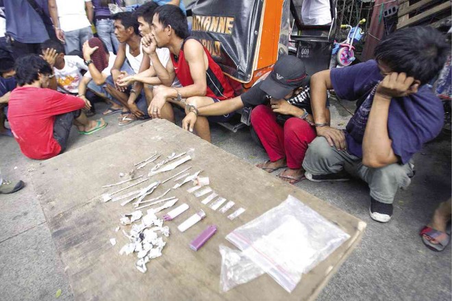 FOILED AND BUSTED  Drug suspects and their tools for getting “high” are prepared for transport to the police station following Thursday’s raid in a Quezon City slum area. RAFFY LERMA